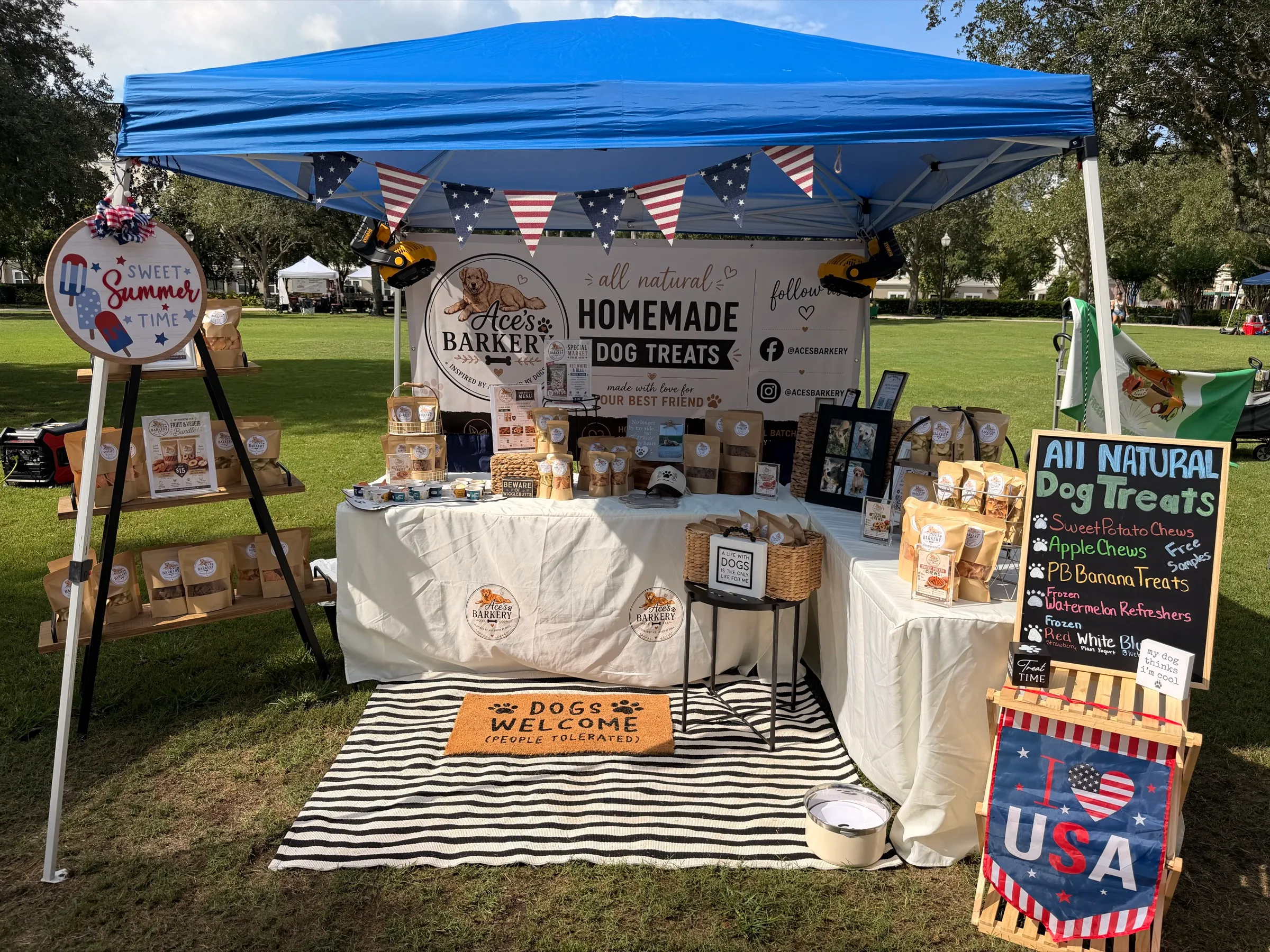 The Ace's Barkery booth under a blue tent at an outdoor market